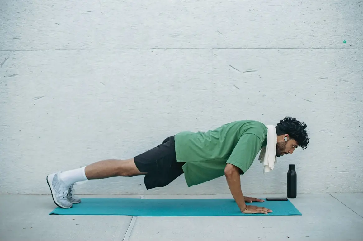 A man doing push ups next to a wall, representing muscles and stamina gain from healthy food. 