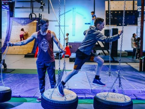 Teenager running across Ninja style obstacle course