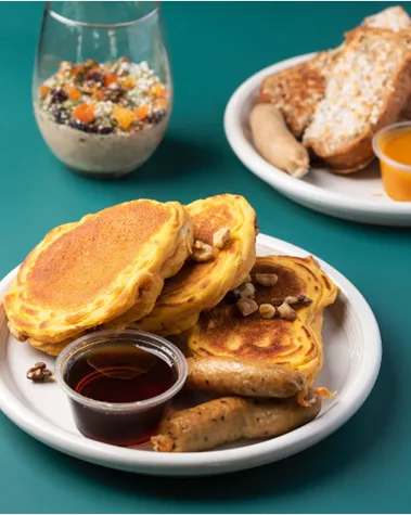 Breakfast spread with pancakes, bacon, and eggs on a table