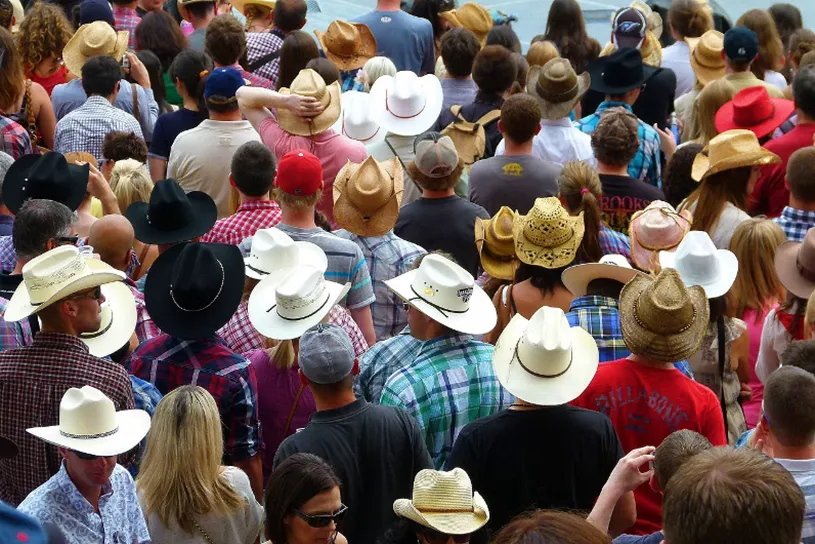 Many individuals wearing cowboy hats in a large group