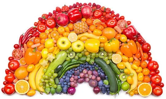 A variety of fruits and vegetables arranged in a rainbow pattern on a white background